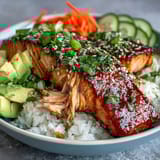 Sweet and savory teriyaki-glazed salmon served over jasmine rice with crisp cucumber, carrot, and avocado slices.  