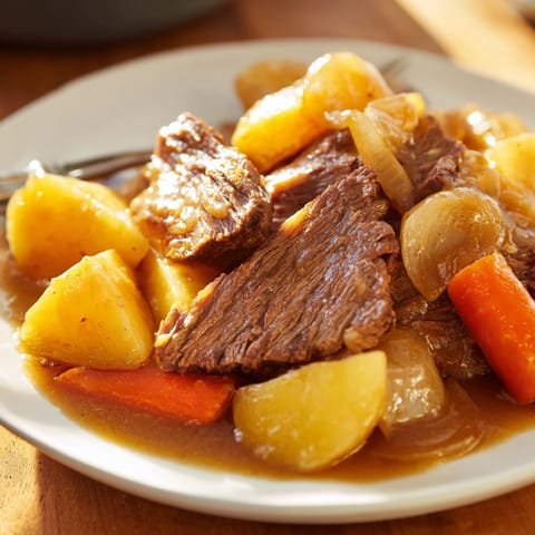 A close-up of a bubbling Beef Pot Roast, showing hearty vegetables and savory meat in a Dutch oven.