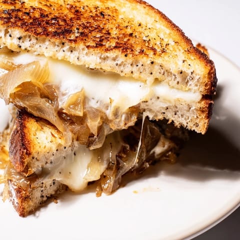 This caramelized onion grilled cheese sandwich is perfectly toasted, with gooey white cheddar and deep amber onions peeking out from the crusty bread.  