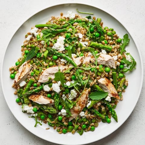 Tender farro, sliced grilled chicken, and bright spring vegetables tossed in a zesty lemon vinaigrette for a refreshing main dish.