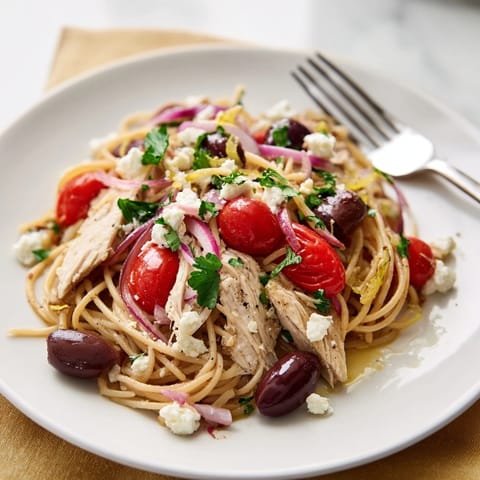 Golden Greek Chicken Spaghetti features juicy grilled chicken, cherry tomatoes, olives, and crumbled feta on pasta.