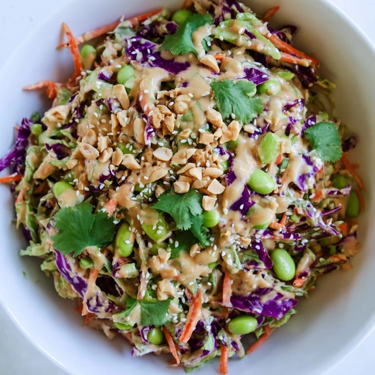 This refreshing Crunchy Thai Peanut Salad is topped with chopped roasted peanuts and sesame seeds, served with fresh lime wedges.
