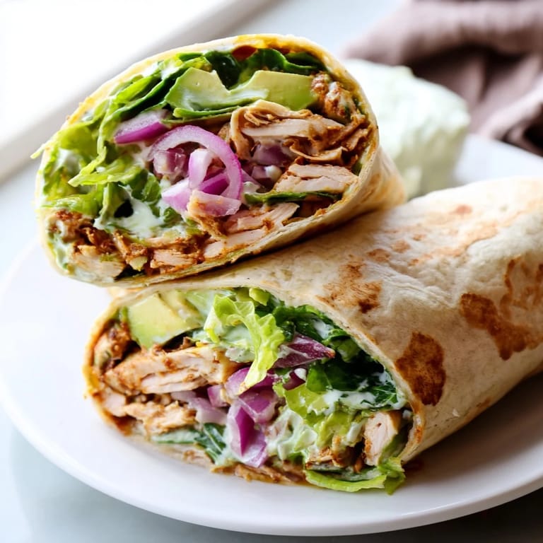 Tender chipotle-marinated chicken is tightly rolled in a warm flour tortilla with fresh red onions and vibrant romaine for a satisfying lunch.