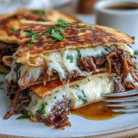 Golden-brown Cinco de Mayo birria quesadillas ready for a savory consommé dip.