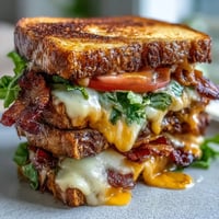 Golden BLT Grilled Cheese melts with crispy bacon, fresh lettuce, and tomatoes.