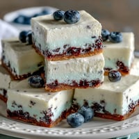 Creamy no-bake lemon blueberry cheesecake bars swirled with vibrant berry goodness.
